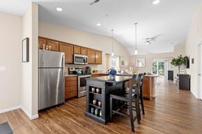 White Lake apartment for rent - A kitchen with a refrigerator, microwave, oven, and a dining table with chairs.