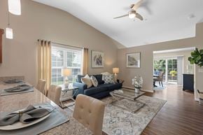 White Lake apartment for rent - A dining room with a table set for two and a couch in the background.
