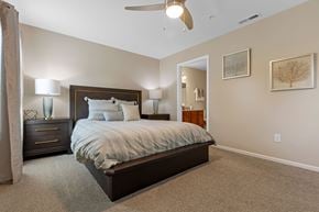 White Lake apartment for rent - A bedroom with a large bed and a ceiling fan.