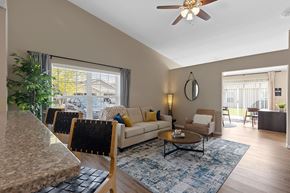 Wolverine Lake apartment for rent - A living room with a couch, chairs, and a ceiling fan.
