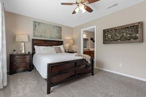 Wolverine Lake apartment for rent - A bedroom with a large bed and a ceiling fan.