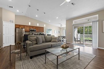 Ypsilanti apartment for rent - A modern living room with a grey couch and a glass coffee table.