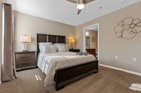 Ypsilanti apartment for rent - A bedroom with a large bed and a ceiling fan.