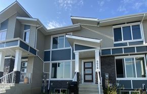 Edmonton apartment for rent - A modern two-story house with a balcony and a garage door.