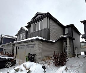 Edmonton apartment for rent - A house with a grey exterior and a black car parked in front.