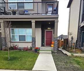 Leduc triplex for rent - A house with a red door and a balcony with a table and chairs.