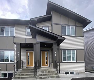 Leduc apartment for rent - A modern house with a grey exterior and a brown front door.