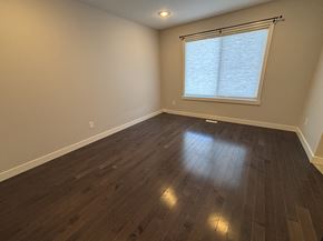 Edmonton apartment for rent - A room with wooden flooring and a window with blinds.