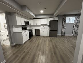 Edmonton apartment for rent - A kitchen with wooden floors and white cabinets.