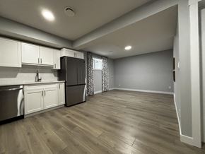 Edmonton apartment for rent - A kitchen with wooden floors and white cabinets.