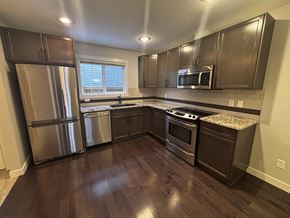 Edmonton apartment for rent - A kitchen with dark wood floors and stainless steel appliances.