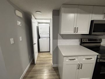 Edmonton apartment for rent - A kitchen with white cabinets and a white refrigerator.