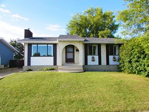 Edmonton apartment for rent - A house with a white door and a window is surrounded by a green lawn.