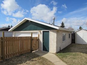 Edmonton apartment for rent - A small house with a green door and a brown fence.