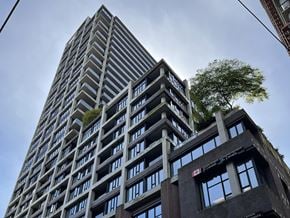 Vancouver condo for rent - a tall building with a tree on top of it