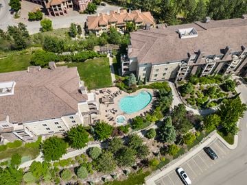Kelowna condo for rent - An aerial view of a residential area with a swimming pool.