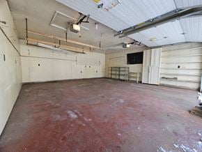 Edmonton apartment for rent - A large, empty garage with a red floor and white walls.
