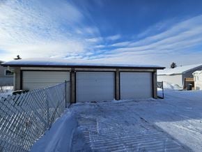 Edmonton apartment for rent - A snow-covered garage with a chain-link fence in front.