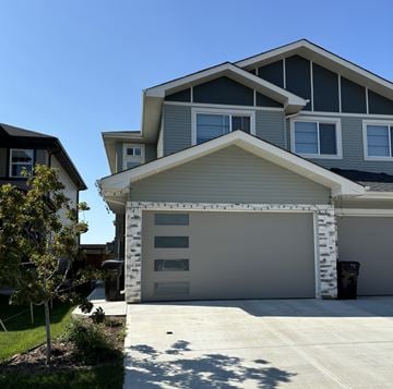 Leduc triplex for rent - A modern house with a grey garage door.