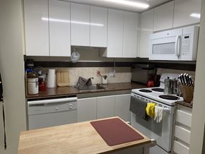 Vancouver apartment for rent - a kitchen with white cabinets and a white stove top oven