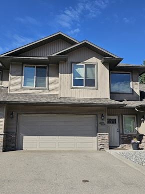 Lake Country townhouse for rent - A house with a grey garage door and a brown roof.