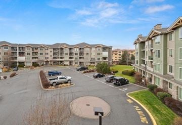 Kelowna condo for rent - A parking lot in front of apartment buildings with cars parked.