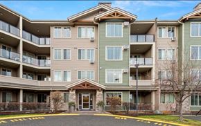 Kelowna condo for rent - A large apartment complex with a central courtyard and a no parking zone in front.