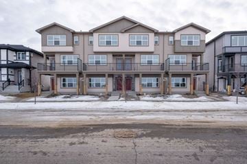 Leduc triplex for rent - A row of multi-story apartment buildings with balconies and doors.
