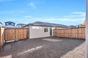 Leduc triplex for rent - A backyard with a wooden fence and a gravel ground.