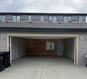 Leduc triplex for rent - A garage with a brown door and a grey wall.