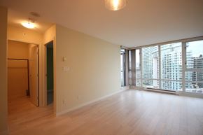 Vancouver apartment for rent - an empty living room with a large window and wooden floors