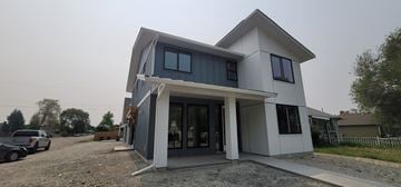 Kelowna apartment for rent - A modern house with a grey and white exterior is shown.