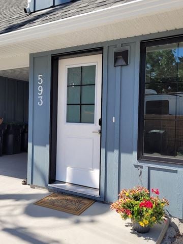 Kelowna house for rent - A white door with a glass window is on a grey house.