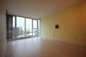 Vancouver apartment for rent - an empty living room with yellow walls and a view of the city