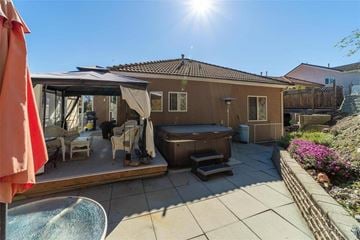 Kelowna apartment for rent - A sunny day at a patio with a hot tub and chairs.