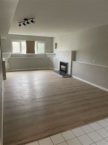 Coquitlam apartment for rent - a living room with a fireplace and a wooden floor