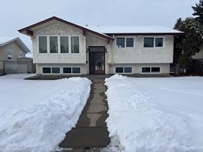 Edmonton apartment for rent - A house with a snow-covered front yard and a path leading to the front door.