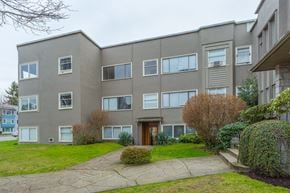 Vancouver apartment for rent - A grey building with a brown door and windows.