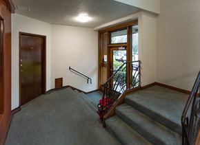 Vancouver apartment for rent - A staircase with a metal railing and a wooden door.