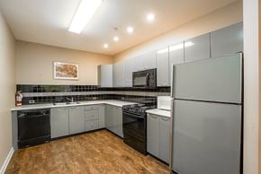 Vancouver condo for rent - A kitchen with black appliances and wooden floors.