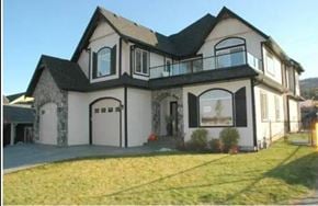 Kelowna apartment for rent - A large two-story house with a balcony on the second floor.