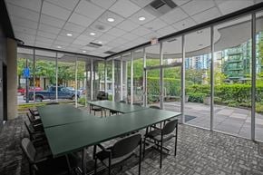Vancouver condo for rent - A conference room with a long table and chairs, large windows, and a view of the outdoors.