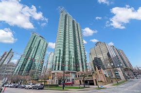 Vancouver condo for rent - A modern glass building stands tall in a cityscape.