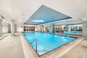 Vancouver condo for rent - A large indoor swimming pool with a blue tiled floor.
