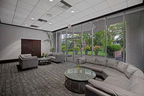 Vancouver condo for rent - A spacious room with grey couches and a glass table.