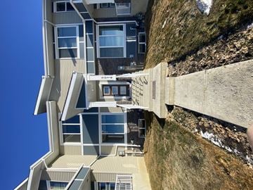 Edmonton apartment for rent - A modern building with a unique design is perched on the edge of a cliff.