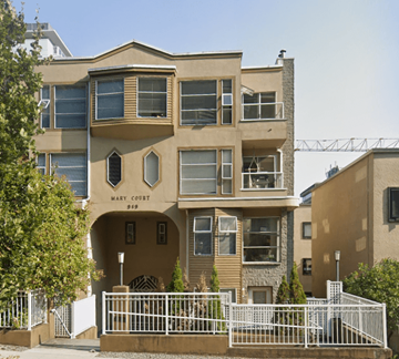Vancouver apartment for rent - an apartment building with a fence in front of it