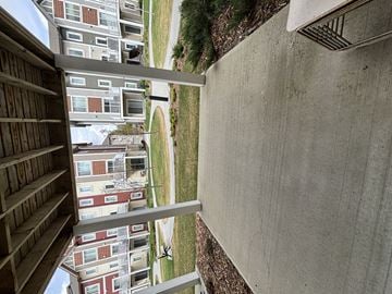 Edmonton townhouse for rent - A concrete wall with a metal railing in the foreground and apartment buildings in the background.