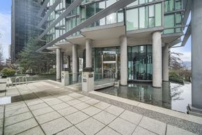 Vancouver condo for rent - A modern building with a glass facade and a water feature in front.