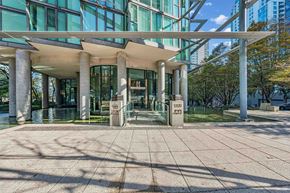 Vancouver condo for rent - A modern building with glass windows and a white roof.
